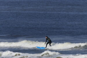 Surfer surft voor het witte schuim uit