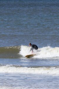 surfen in shorebreak met een surfboard van de verhuur