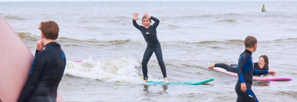 Een surfer juicht tijdens de surfles