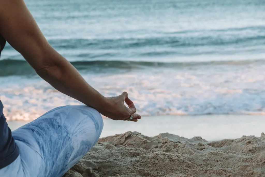 Dame doet yoga op het strand